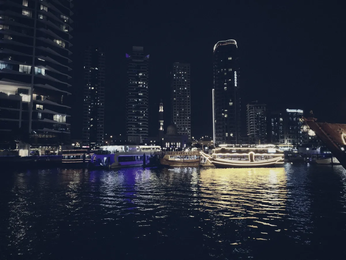 Dubai Marina skyline at night with illuminated boats on the water